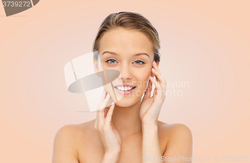 Image of smiling young woman touching her face