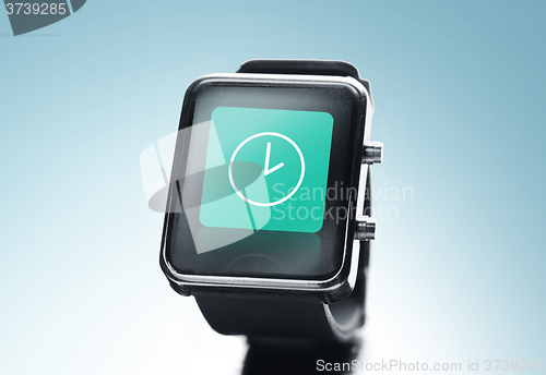 Image of close up of black smart watch with clock icon