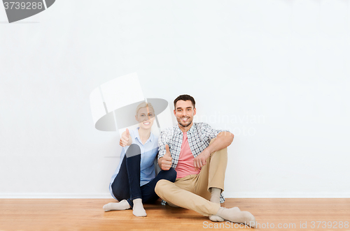 Image of happy couple showing thumbs up at new home