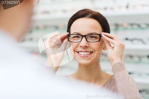 Image of woman choosing glasses at optics store