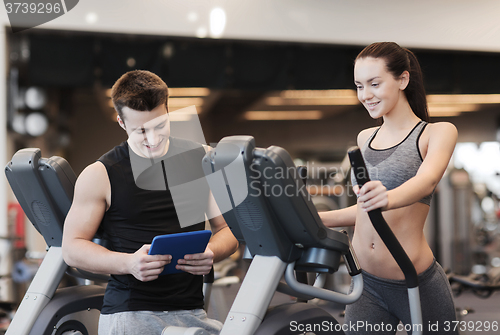 Image of woman with trainer exercising on stepper in gym