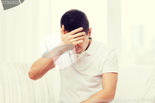 Image of unhappy man suffering from head ache at home