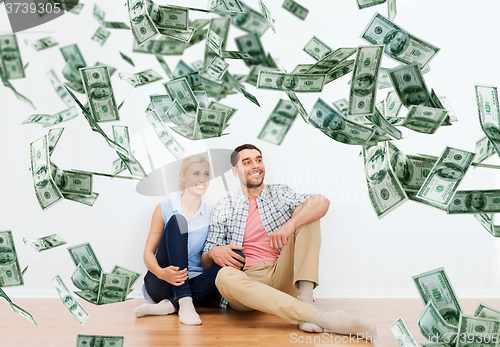 Image of happy couple at home over dollar money falling