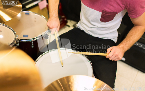 Image of close up of male musician playing on drum kit