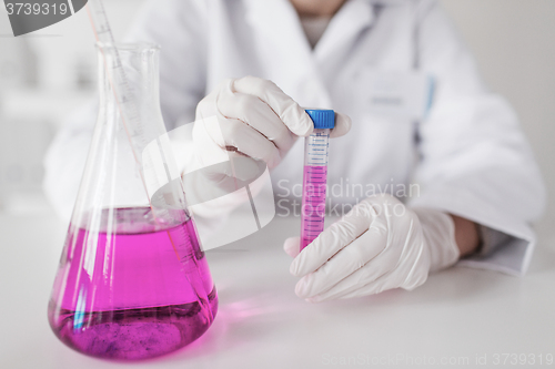 Image of close up of scientist with tube in laboratory