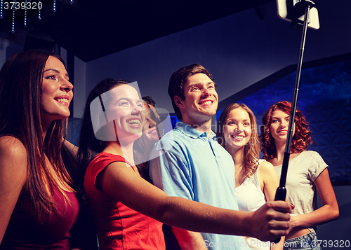 Image of friends with smartphone taking selfie in club