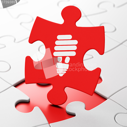 Image of Business concept: Energy Saving Lamp on puzzle background