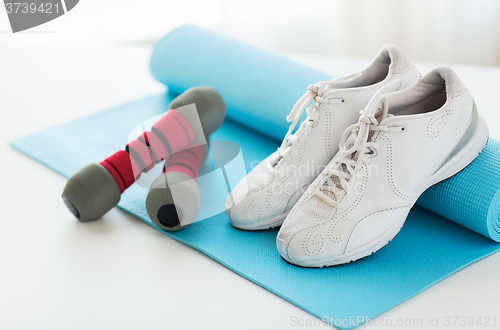 Image of close up of sneakers, dumbbells and sports mat