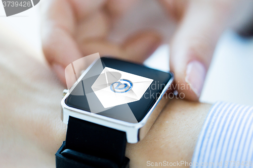 Image of close up of hands with email icon on smartwatch