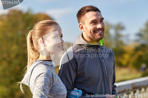 Image of smiling couple with bottles of water outdoors