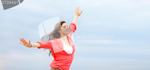 Image of girl with hands up on the beach