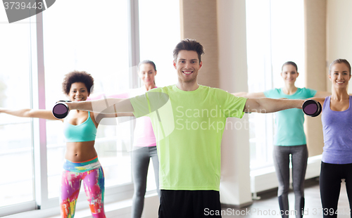 Image of group of smiling people working out with dumbbells