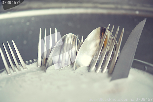 Image of close up of dirty dishes washing in kitchen sink