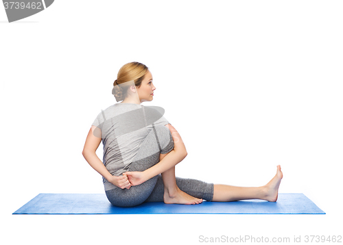 Image of woman making yoga in twist pose on mat