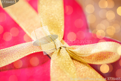 Image of close up of red heart shaped gift box with bow