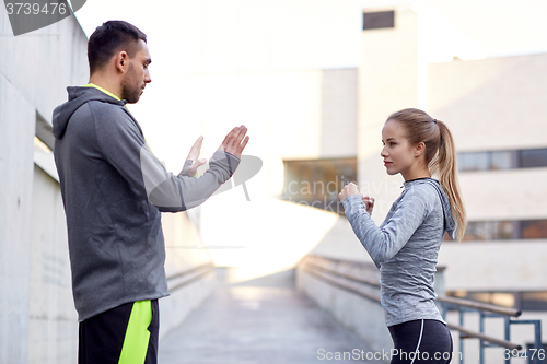 Image of woman with coach working out strike outdoors