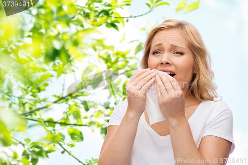 Image of unhappy woman with paper napkin sneezing