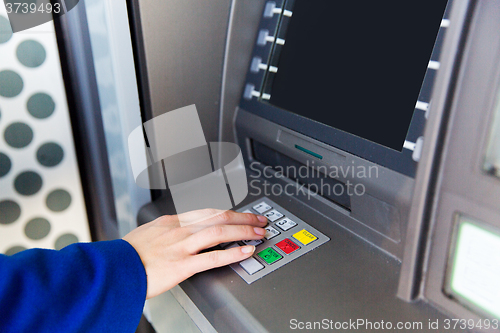 Image of close up of hand entering pin code at cash machine