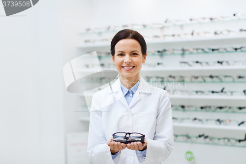 Image of woman optician holding glasses at optics store