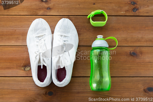 Image of close up of sneakers, bracelet and water bottle