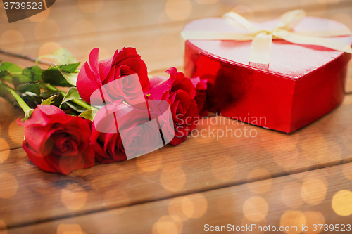 Image of close up of heart shaped gift box and red roses