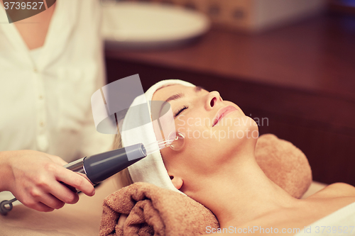 Image of close up of young woman having face massage in spa