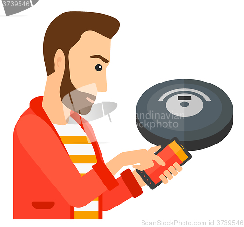 Image of Man with robot vacuum cleaner.