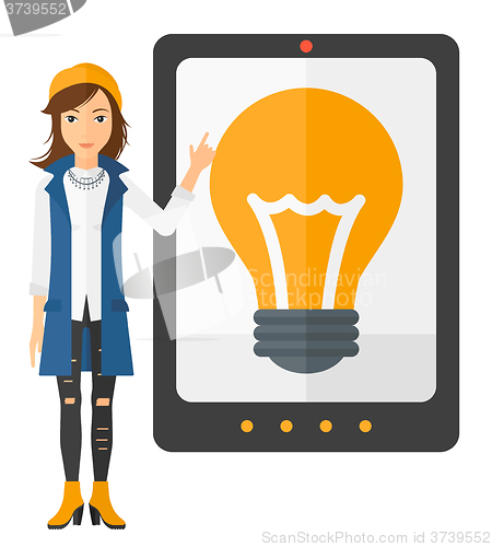 Image of Woman pointing at tablet computer with light bulb on screen.