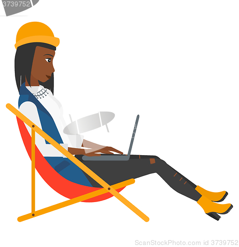 Image of Business woman sitting in chaise lounge with laptop.