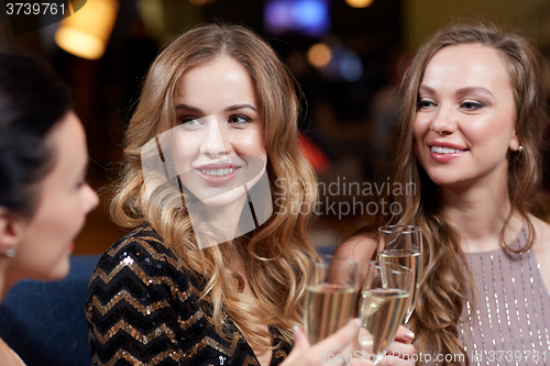 Image of happy women with champagne glasses at night club