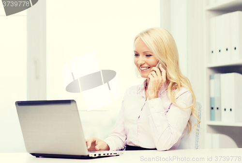 Image of smiling businesswoman calling on smartphone