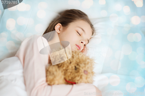 Image of girl sleeping with teddy bear toy in bed