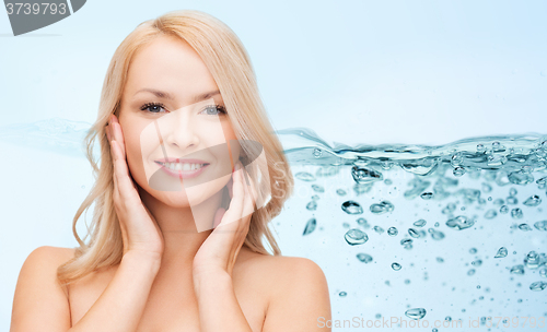 Image of smiling young woman touching her face