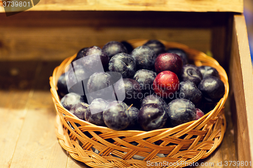 Image of ripe plums in basket at farm or food market