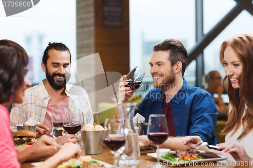 Image of friends dining and drinking wine at restaurant