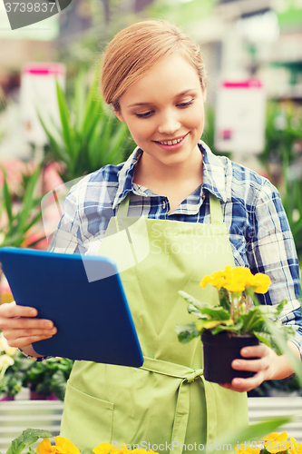 Image of happy woman with tablet pc in greenhouse