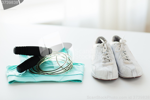 Image of close up of sports top, sneakers and skipping rope