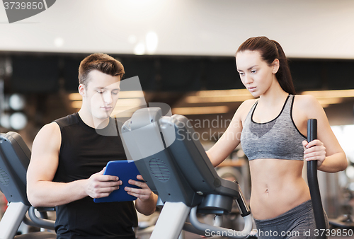 Image of woman with trainer exercising on stepper in gym