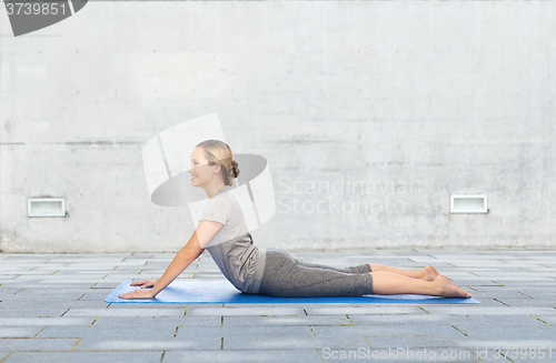 Image of woman making yoga in dog pose on mat