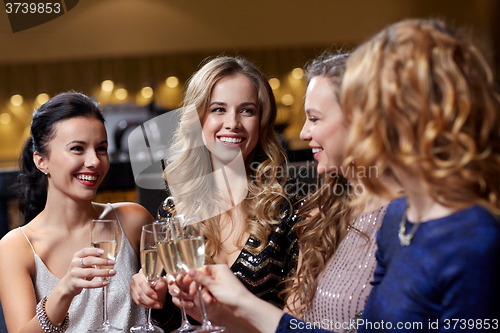 Image of happy women with champagne glasses at night club