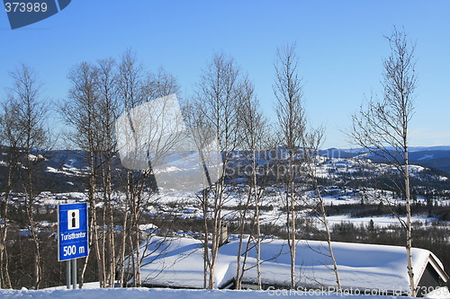 Image of Tourist office sign and cabins in winter landscape