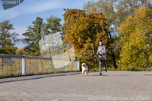 Image of happy man with labrador dog running outdoors