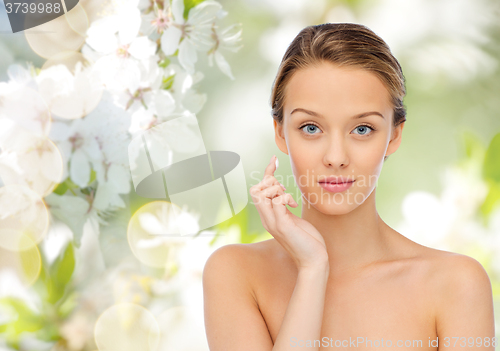 Image of young woman applying cream to her face