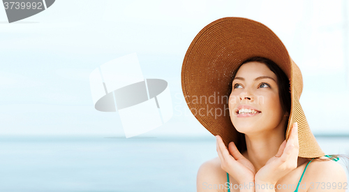 Image of girl in hat standing on the beach