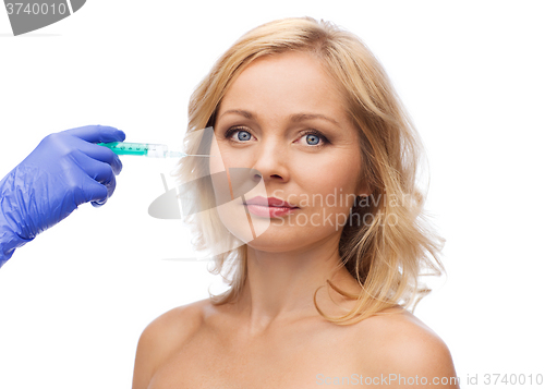 Image of woman face and beautician hand with syringe