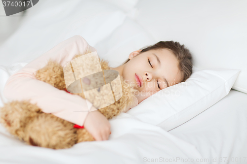 Image of girl sleeping with teddy bear toy in bed at home