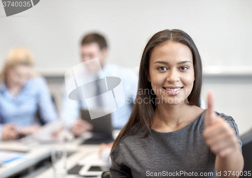 Image of group of smiling businesspeople meeting in office