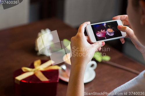 Image of close up of hands with smartphone taking picture