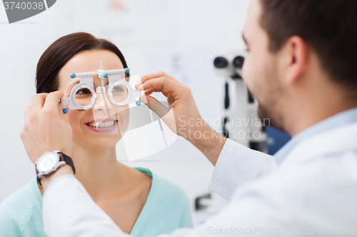 Image of optician with trial frame and patient at clinic