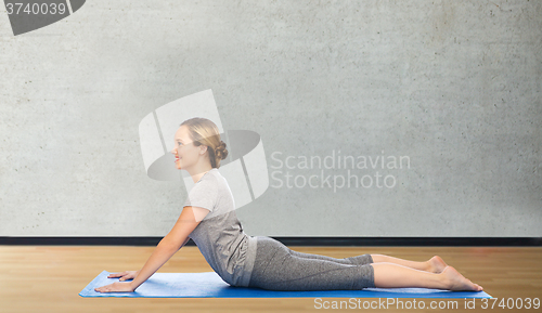 Image of woman making yoga in dog pose on mat